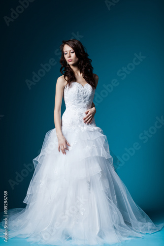 beautiful bride in wedding dress on blue