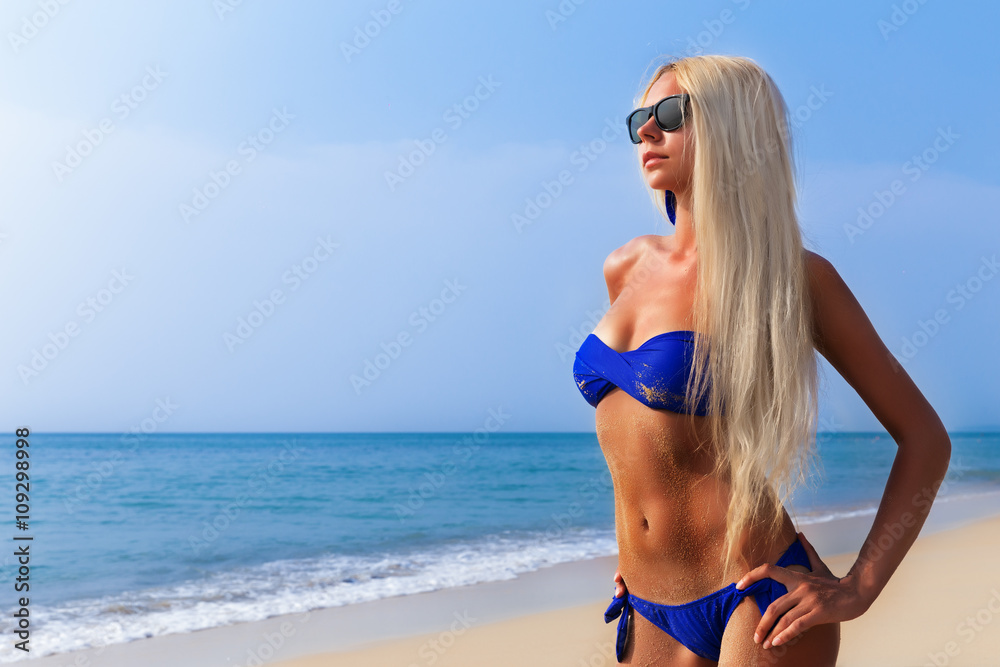 Slim blonde long haired woman in bikini on tropical beach Slim blonde long haired woman in bikini on tropical beach
