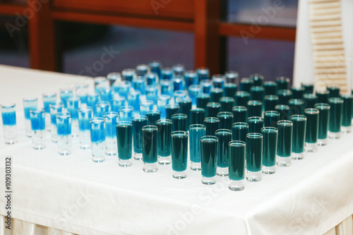 Blue alcohol shots on the white table
