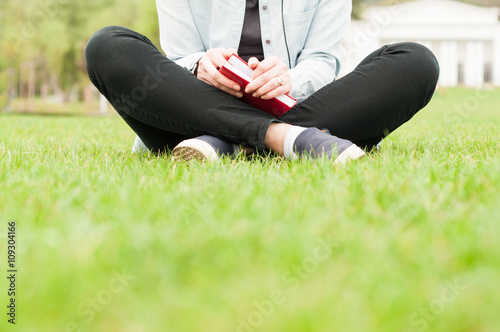 Close-up of woman standing on grass and holding book or diary