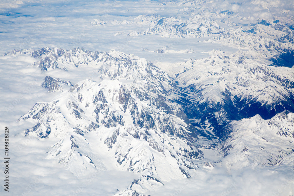 Alps with snow view through the white clouds