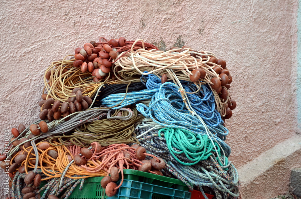 Image of fishing nets, floats, and rusty chain at seaside harbour