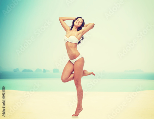 happy young woman in white bikini swimsuit