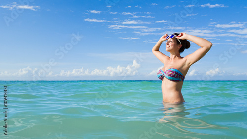 Relaxed woman in bikini enjoying caribbean tropical vacation into turquoise sea.