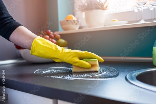 woman's hands cleaning kitchen cabinets
