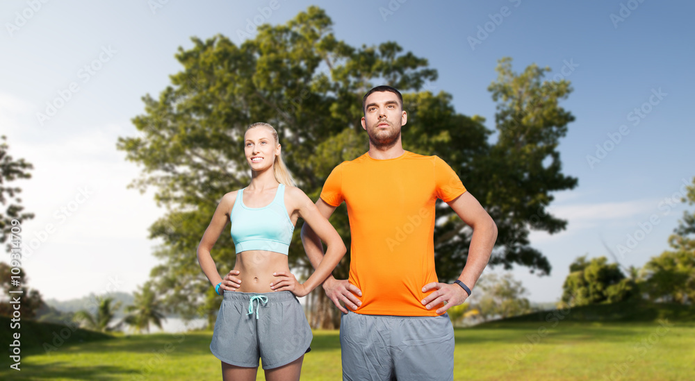 happy couple exercising over summer park