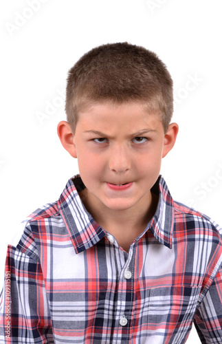 young boy making a mean face isolated on white background