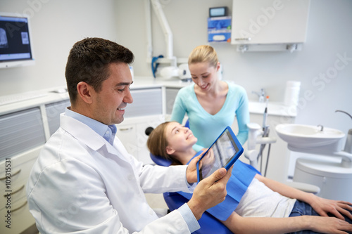 dentist with x-ray on tablet pc and patient girl