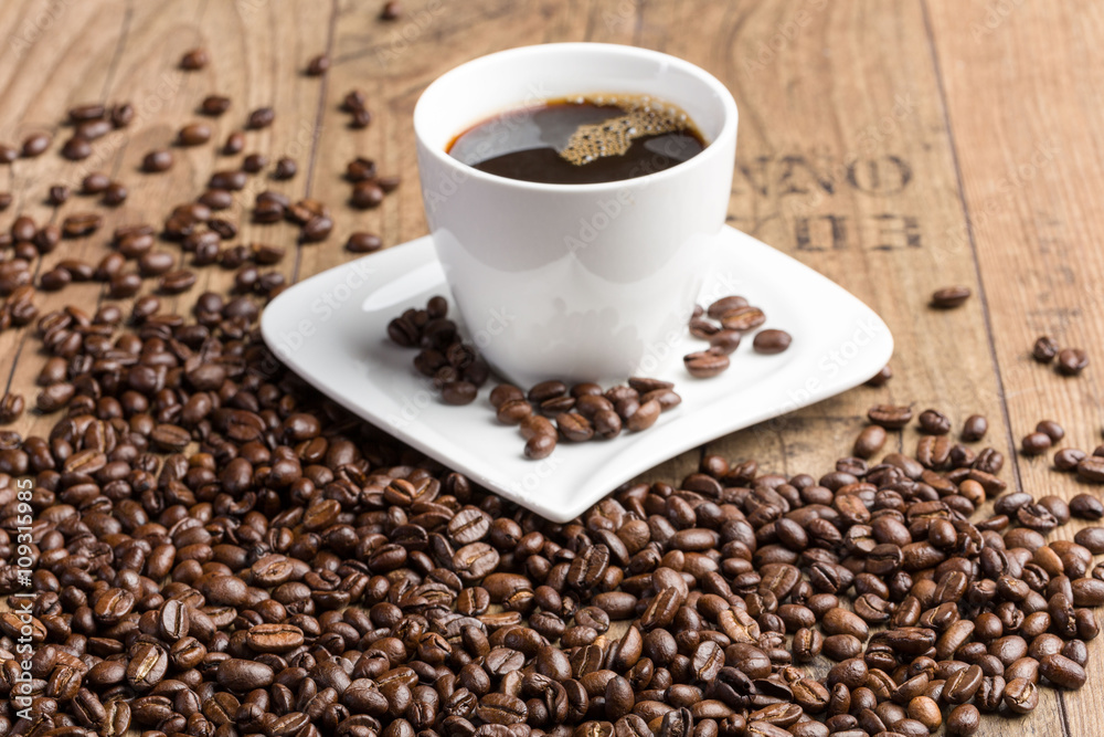 Tasse schwarzer Kaffee und Kaffeebohnen auf Holz Tasse schwarzer Kaffee und Kaffeebohnen auf Holz
