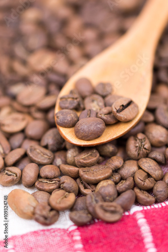 Coffee beans on the wooden spoon macro closeup