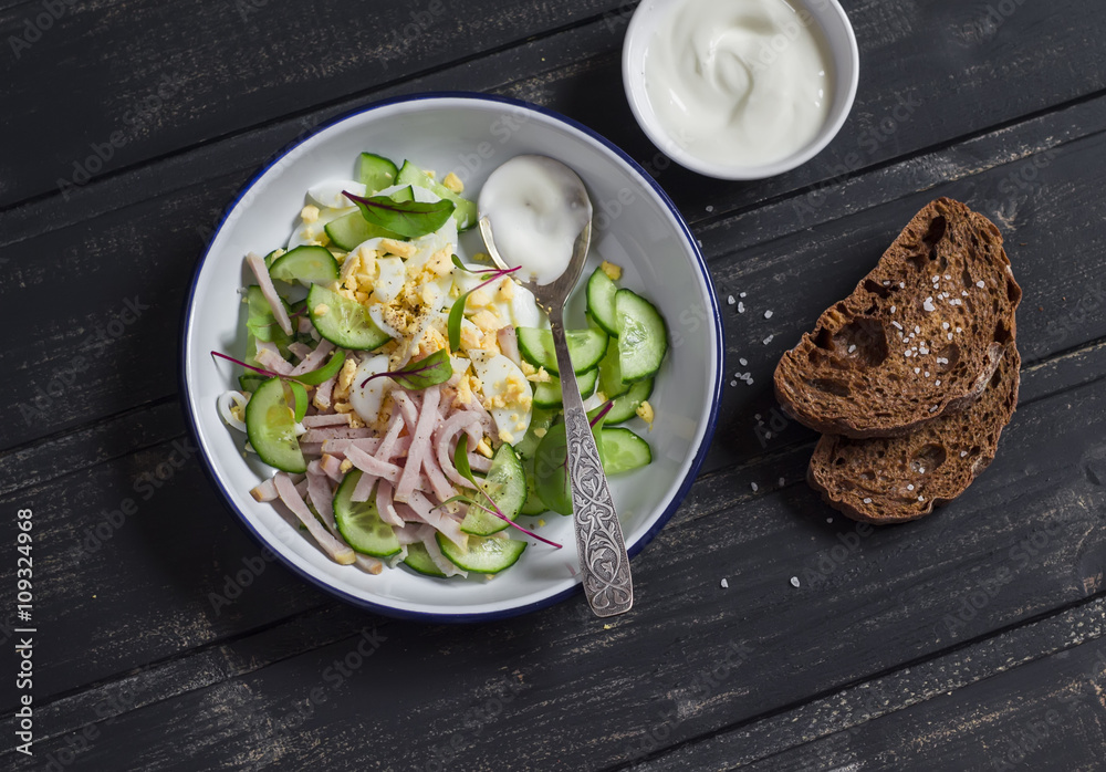 Salad with smoked turkey, cucumber and boiled egg on a dark wooden background. Healthy food Salad with smoked turkey, cucumber and boiled egg on a dark wooden background. Healthy food