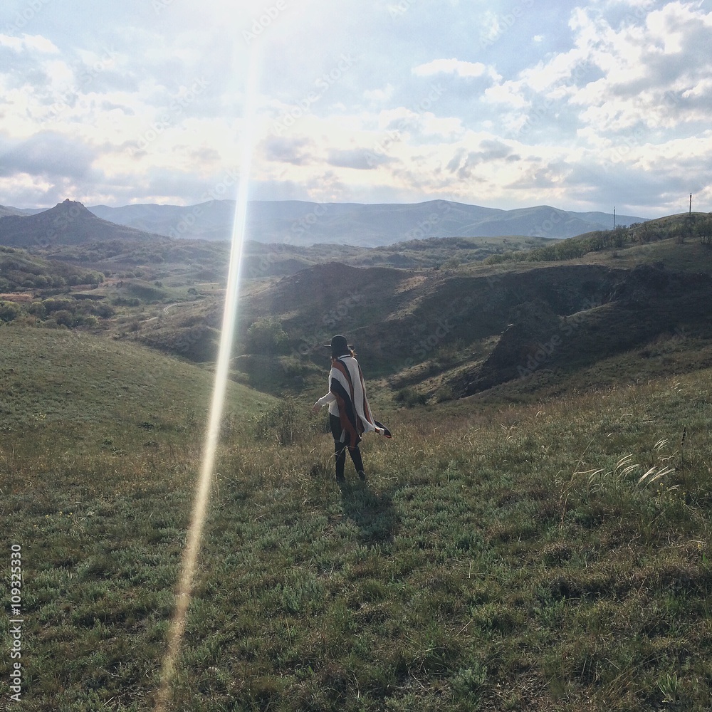 Traveler woman standing on a top of the hill Traveler woman standing on a top of the hill