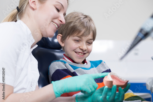 Friendly child dentist trying to cheer up her little patient