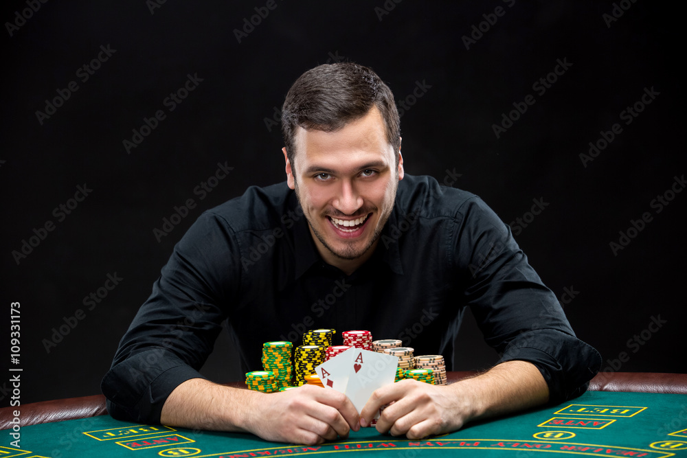 Happy poker player winning and holding a pair of aces Happy poker player winning and holding a pair of aces