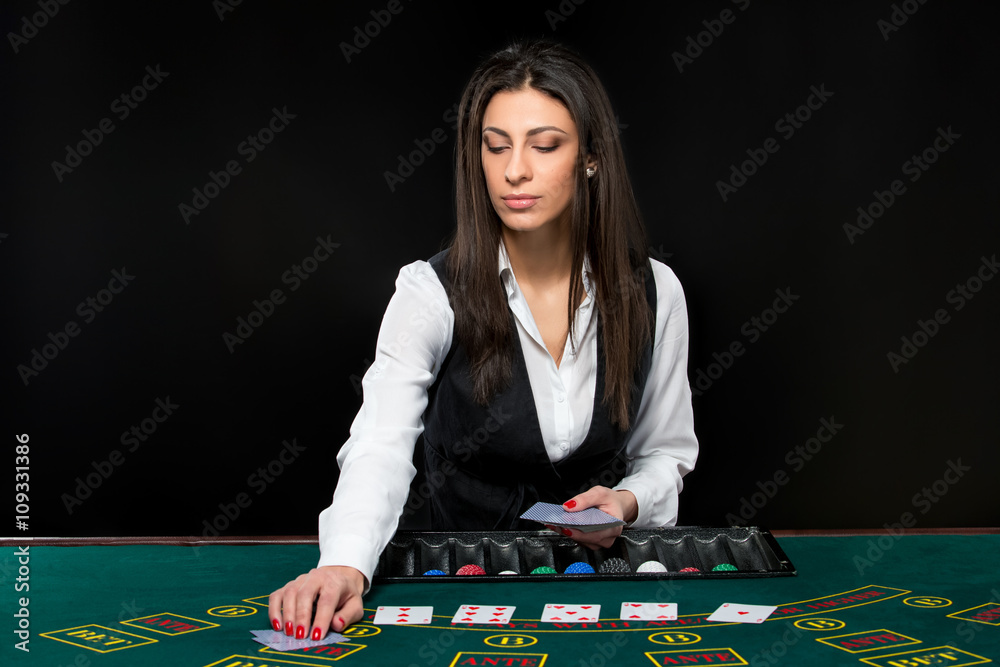 The beautiful girl, dealer, behind a table for poker The beautiful girl, dealer, behind a table for poker