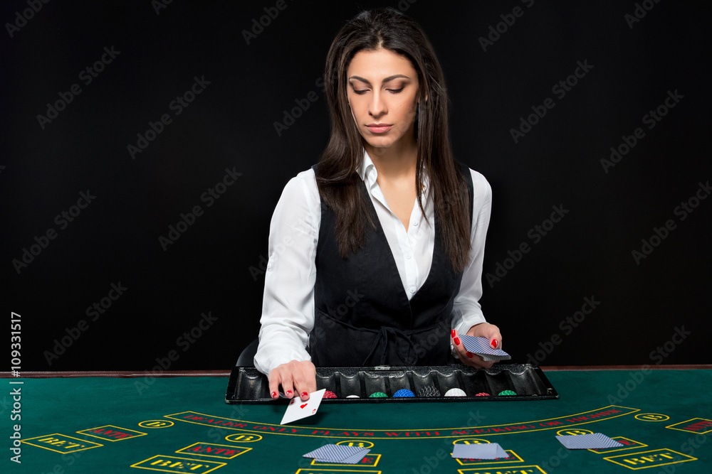 The beautiful girl, dealer, behind a table for poker The beautiful girl, dealer, behind a table for poker