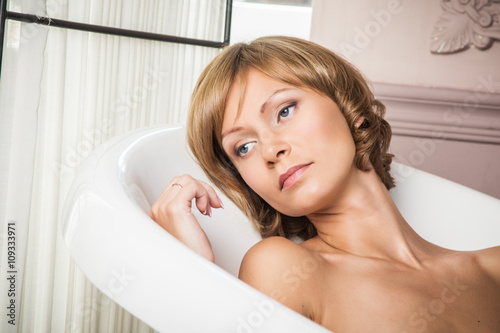 Portrait of beautiful young woman taking a bath