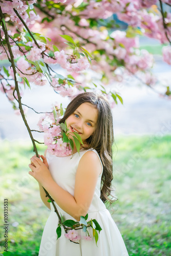 Small pretty girl in blossom