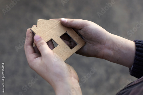 homeless boy holding a cardboard house photo