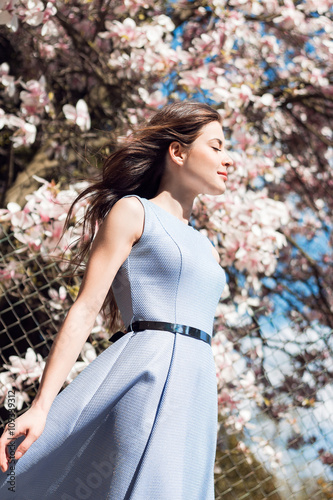 Beautiful girl near magnolia tree