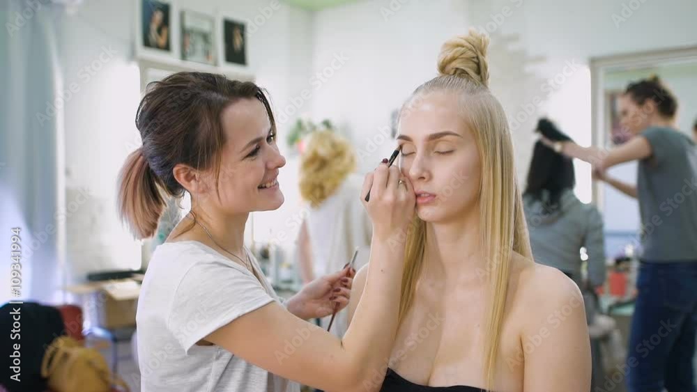 Transformation. In the trendy beauty salon, a professional makeup artist prepares the image for an attractive blonde. Transformation. In the trendy beauty salon, a professional makeup artist prepares the image for an attractive blonde.