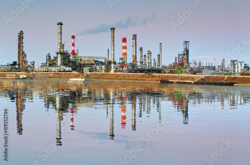 Oil refinery at night with reflection in water