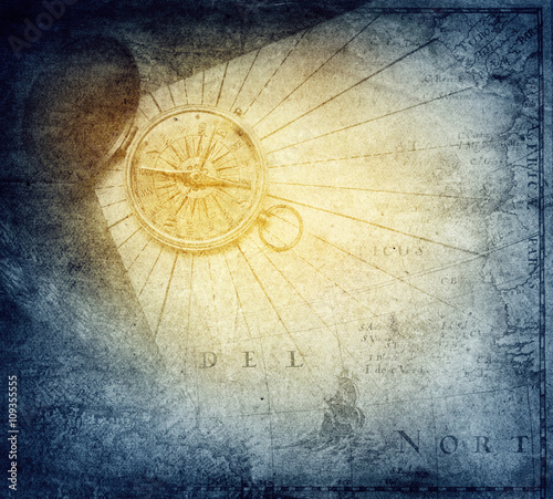 Vintage golden compass with nautical map background.