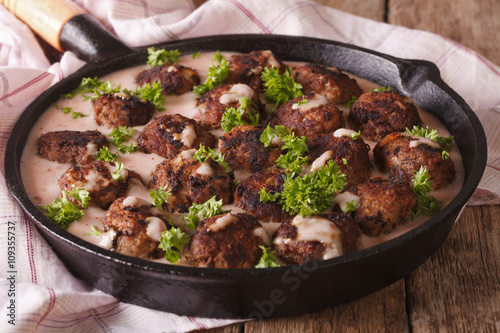 Swedish cuisine: kottbular with cowberry sauce closeup on a pan. horizontal 