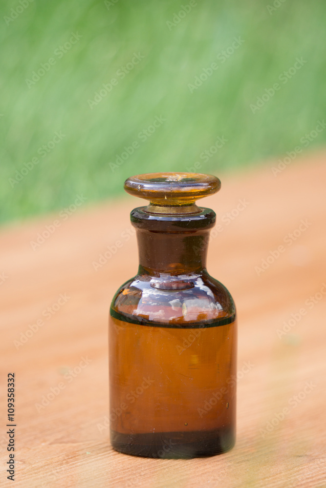 little brown bottle on booden board and grass