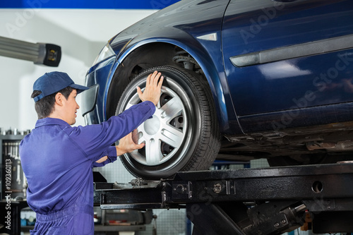 Mechanic Fixing Alloy To Car Tire