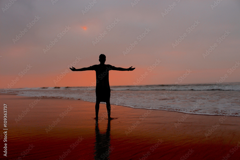 Freedom. Young man standing with arms stretched. 