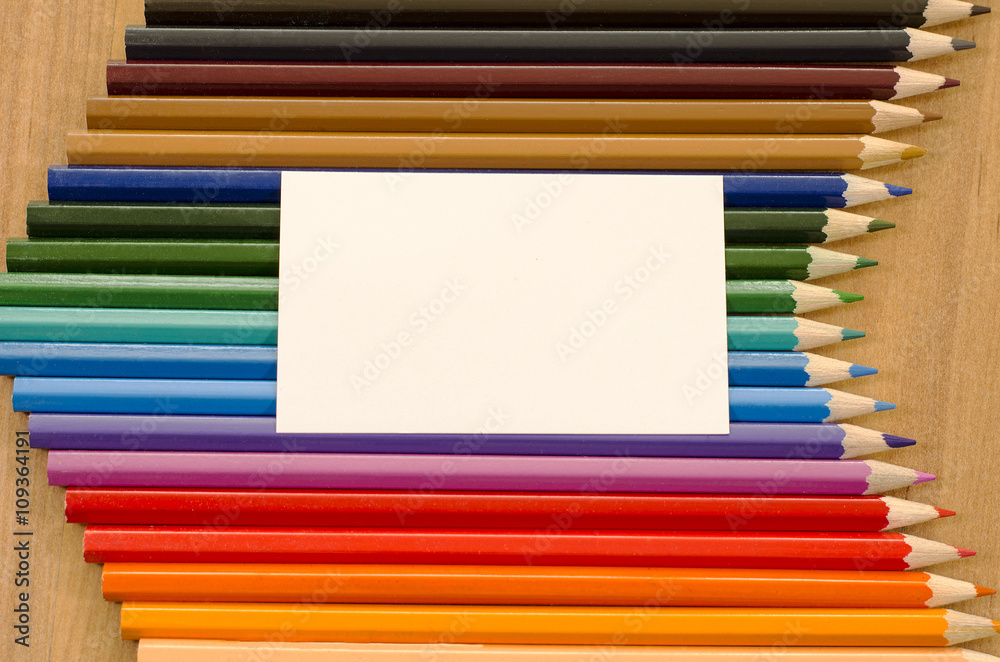 Blank white paper and colored pencil on wooden background Blank white paper and colored pencil on wooden background