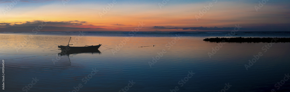 Sunset with fisher boat and still water on Gili Air Island, Indo