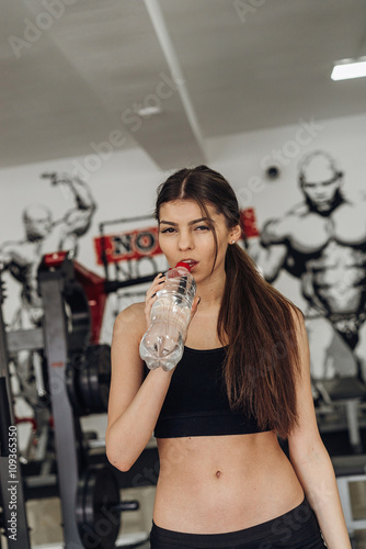 Beautiful girl with water at the gym