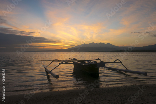 Sunrise with tourist boat and still water on Gili Air Island, In