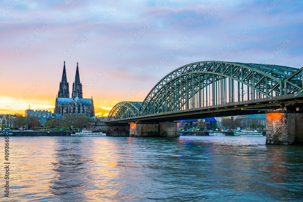 Naklejka premium Sunset at the Cologne Cathedral with Hohenzollern Bridge in Colo