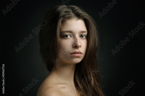 Dramatic portrait of a girl theme: portrait of a beautiful girl on a background in the studio