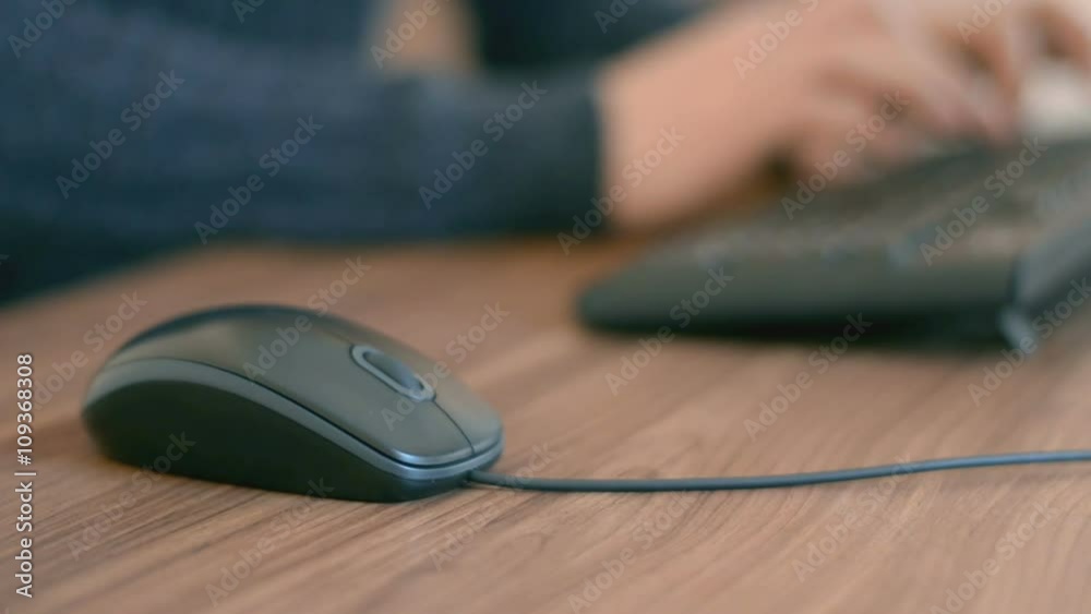 Hand of a man working at computer clicking on mouse typing text on keyboard Hand of a man working at computer clicking on mouse typing text on keyboard