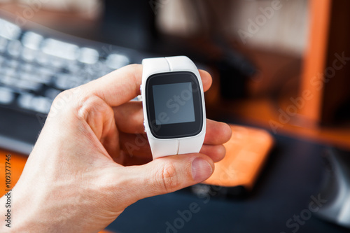 Hand holding a modern smart watch. Blank screen for placing your own information