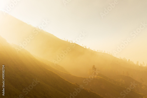 Fog covered mountain layer with the golden light on morning.