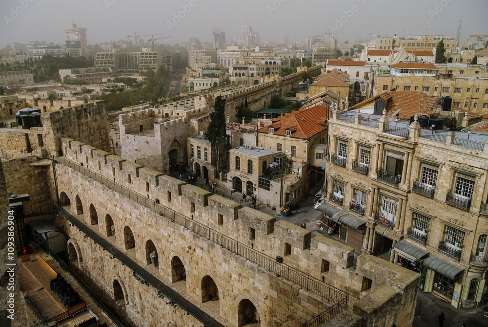 Walls and castle of old city. Jerusalem panoramic roof view in time of sand storm. Israel