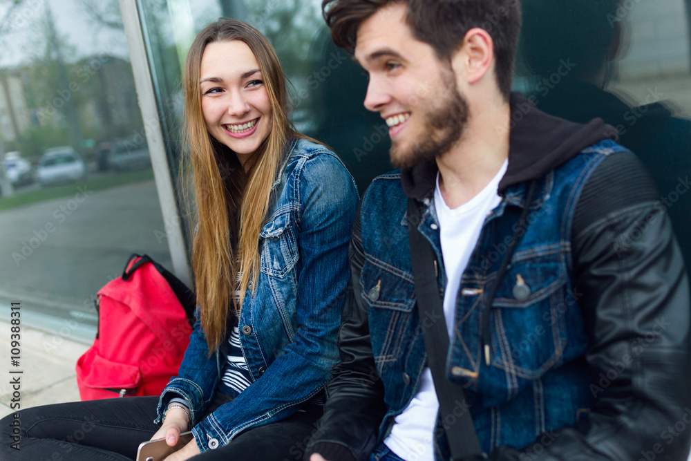Obraz premium Two students talking in the street after class.