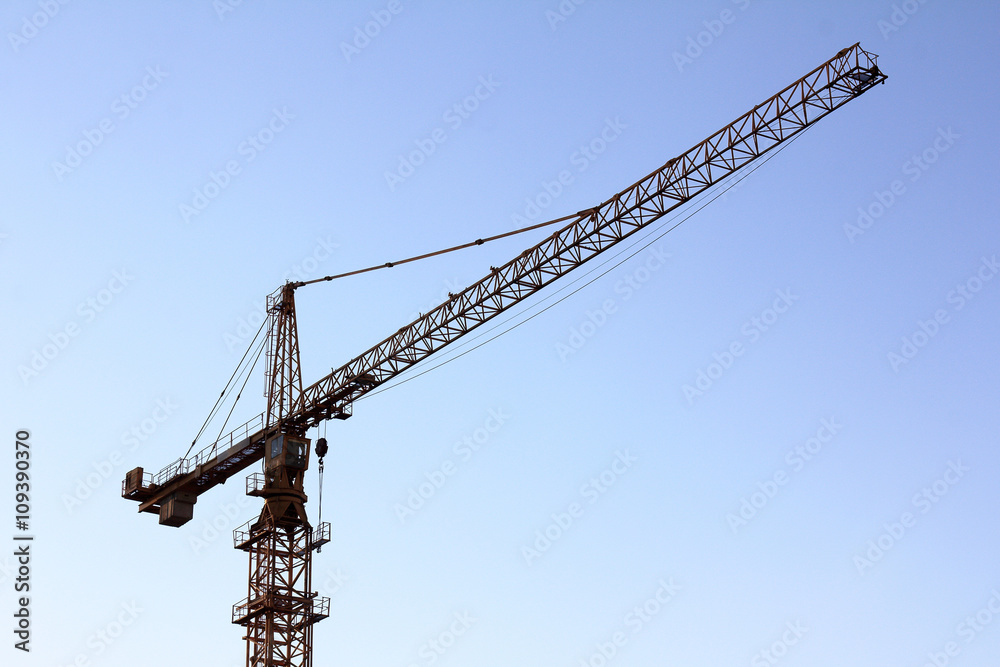 High construction site/high construction tower crane against the blue sky