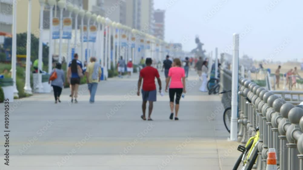 Tourists walk along the famous Virginia Beach boardwalk, the longest boardwalk in the US.