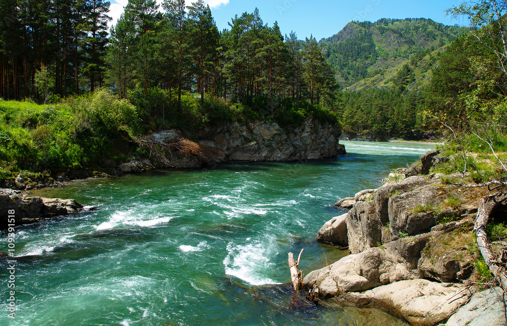 Mountain River among rocks and peaks against the sky and clouds