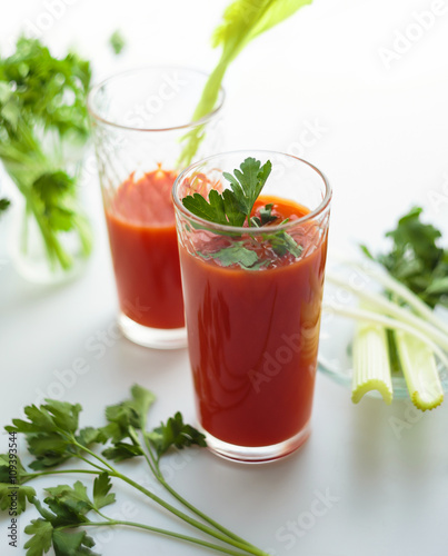 Tomato juice in glasses on white backround