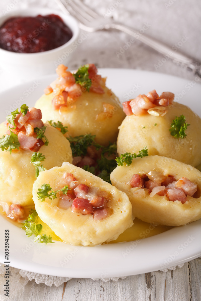 Potato dumplings stuffed with ham and onion close-up and lingonberry sauce. Vertical
Potato dumplings stuffed with ham and onion close-up and lingonberry sauce. Vertical