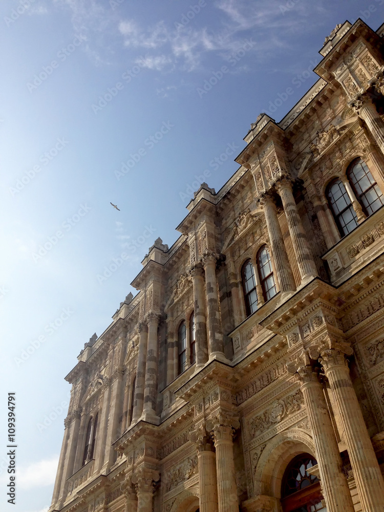 Looking at sky from the bottom of Dolmabahce Palace. Seagulls are flying above the palace