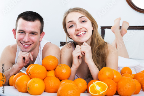 Couple with oranges in bed photo