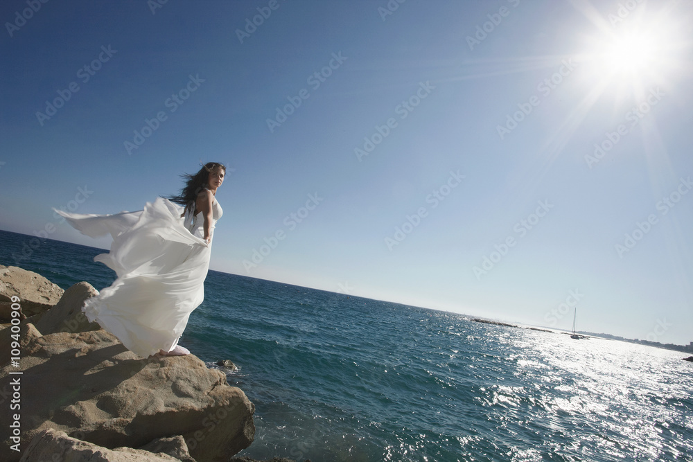 Divine, gorgeous bride standing and posing on the shoreline unde